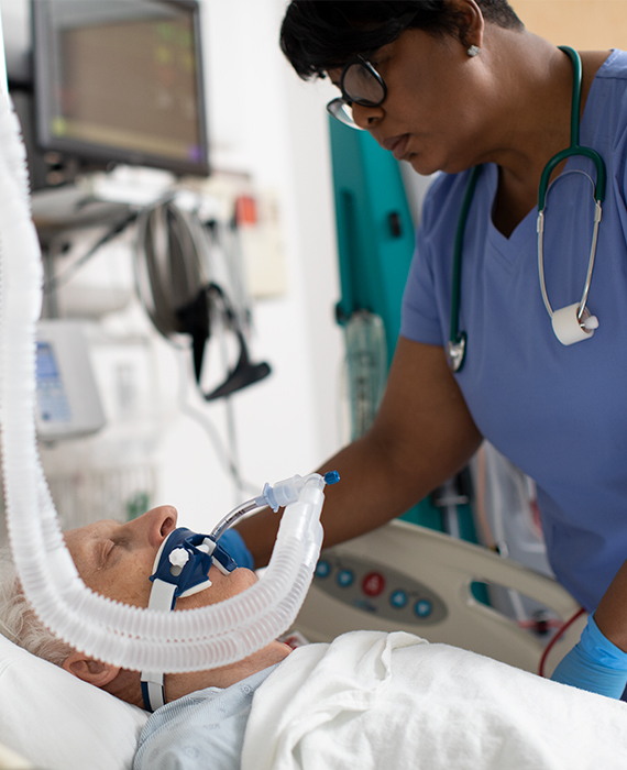Physician at bedside with patient on ventilator