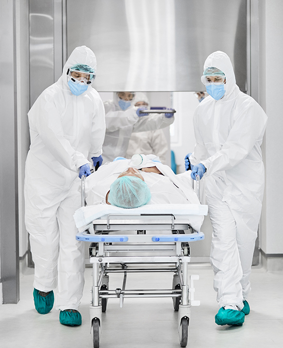 Patient going into surgery with medical professionals wearing PPE